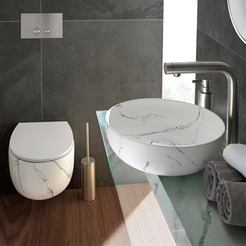 Hvid håndvask og toilet der er marmoreret så det ligner marmor