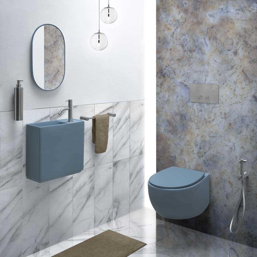 Farvet håndvask til de lille badeværelse samt et blåt toilet