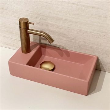 Lille lyserød håndvask med messing armatur 