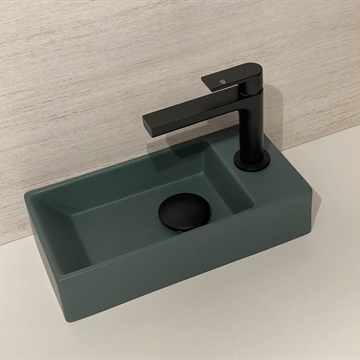 mørkegrøn lille håndvask med sort armatur