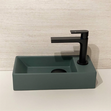 Grøn håndvask på lille badeværelse
